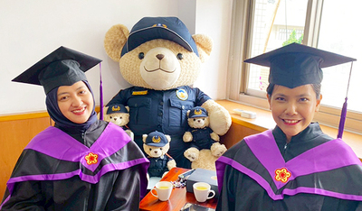 畢業外籍生與警察熊讚娃娃合影