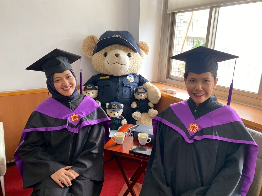 畢業外籍生與警察熊讚娃娃合影